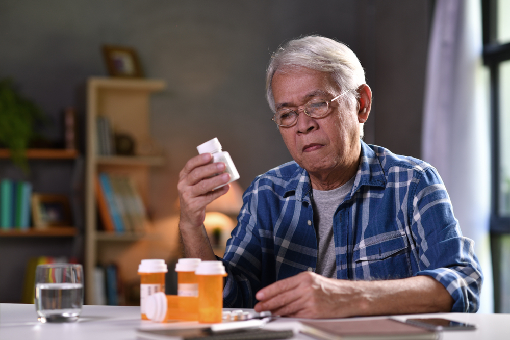 older gentleman looking at the pill bottles